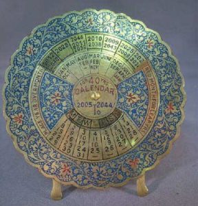 a brass calendar composed of rotating wheels