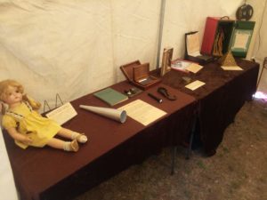 Photo of various artifacts displayed on draped tables with informational signs